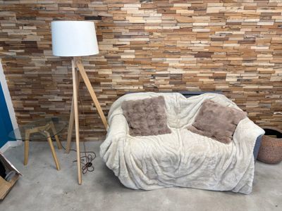 un canapé et une lampe dans une pièce aux murs en briques