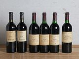 six bouteilles de vin sont alignées sur une table en bois