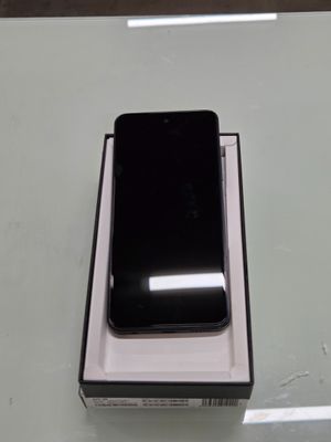 a black cell phone sitting in a box on a table