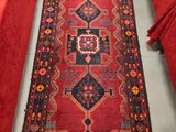 un long tapis rouge posé à même le sol dans une pièce
