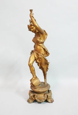 bronze figurine of a woman holding a bird on a pedestal