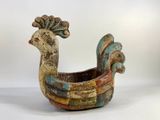 a colorful bird shaped planter sitting on a white surface