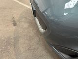 a close up of a car ' s front bumper with a denting on it