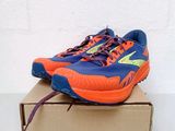a pair of blue and orange running shoes sitting on top of a box