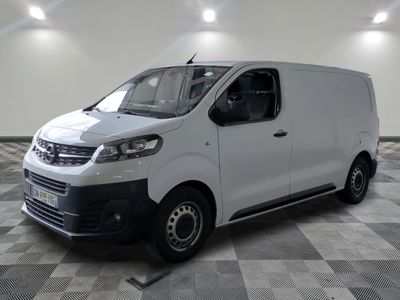la camionnette blanche est garée dans une grande pièce au sol en damier