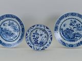 trois assiettes bleues et blanches ornées de fleurs et d'oiseaux