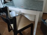 a small table with a chair and a chalk board on the wall