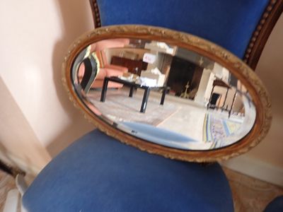 une chaise bleue avec un miroir au dos