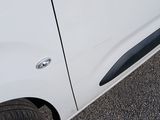 a white van parked in a parking lot with its door open