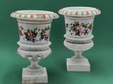 two white vases with floral designs on them on a green background