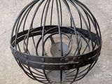 a bird in a cage hanging from the ceiling