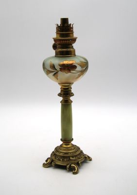 une lampe ancienne en laiton et en verre vert sur fond blanc