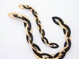 a black and gold necklace on a white background