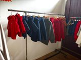 a lot of clothes hanging on a rack in a room