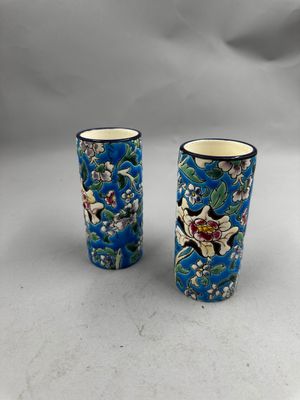 deux vases bleus ornés de motifs floraux, posés sur une table