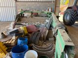 plusieurs seaux et un tracteur dans un bâtiment, avec un tracteur en arrière-plan