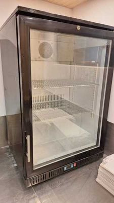 un réfrigérateur avec une porte vitrée au milieu d'une pièce