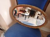 une chaise bleue avec un miroir au dos
