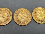 three gold coins, one of which has a crown and one of which has a crown on it