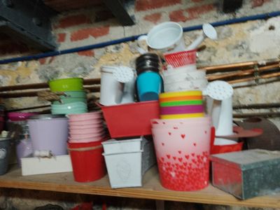 many cups and containers sitting on a shelf in a room