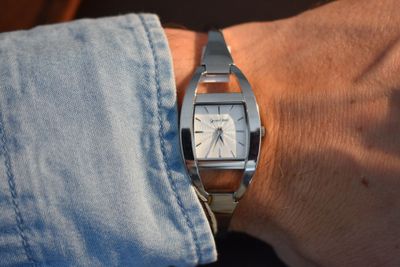 une personne portant une montre en argent au poignet