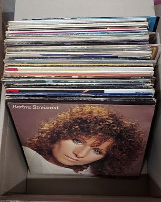 une boîte remplie de disques vinyles posée sur une table