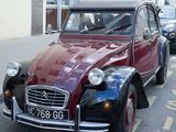 une voiture rouge et noire garée au bord de la rue