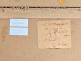 a piece of paper on the ground next to a sign