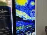 a large painting of a starry night on a large screen