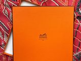 an orange box sitting on top of a red patterned cloth