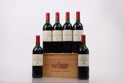 six bottles of red wine in a wooden crate on a table