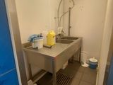 une cuisine équipée d'un évier et d'un plan de travail sur lequel est installé un robinet