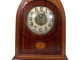 a wooden clock that is sitting on a white surface