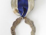 an image of a medal with a ribbon and a ring on it