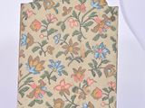 a bag with a floral design on it sitting on a white surface