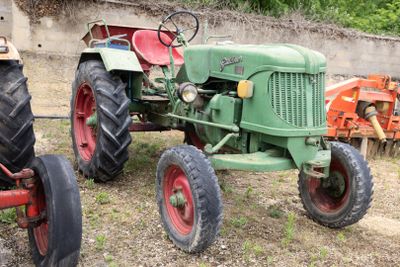 deux vieux tracteurs garés l'un à côté de l'autre dans un champ
