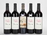 cinq bouteilles de vin sont alignées sur une surface blanche