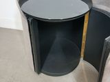 a small black table with a door open in a corner
