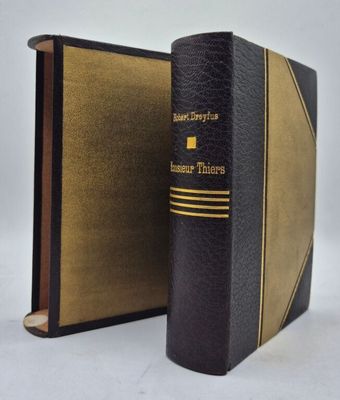 un vieux livre noir orné d'une bande dorée sur la couverture