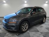 une Volkswagen Tiguan grise garée dans un showroom au sol carrelé