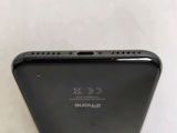 the back of a black cell phone sitting on top of a white table