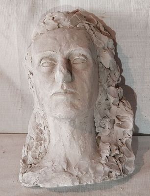 une sculpture en argile représentant la tête d'une femme ornée de fleurs