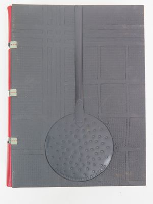 un cahier ouvert, avec une couverture noire et un stylo rouge posé dessus
