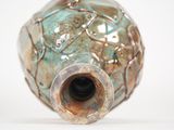 a close up of a vase on a white surface