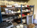 many plates and bowls on the shelves in the kitchen