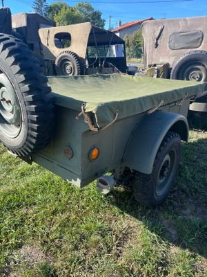 un vieux camion militaire à plateau garé dans l'herbe
