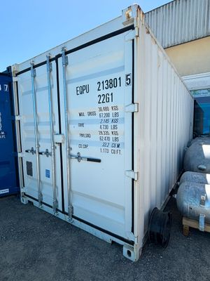 a white shipping container sitting next to a blue container