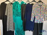 un ensemble de robes suspendues à un portant devant un mur