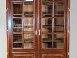 a large wooden bookcase with glass doors and gold trimmings
