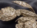 a close up of a brooch with diamonds on a black cloth